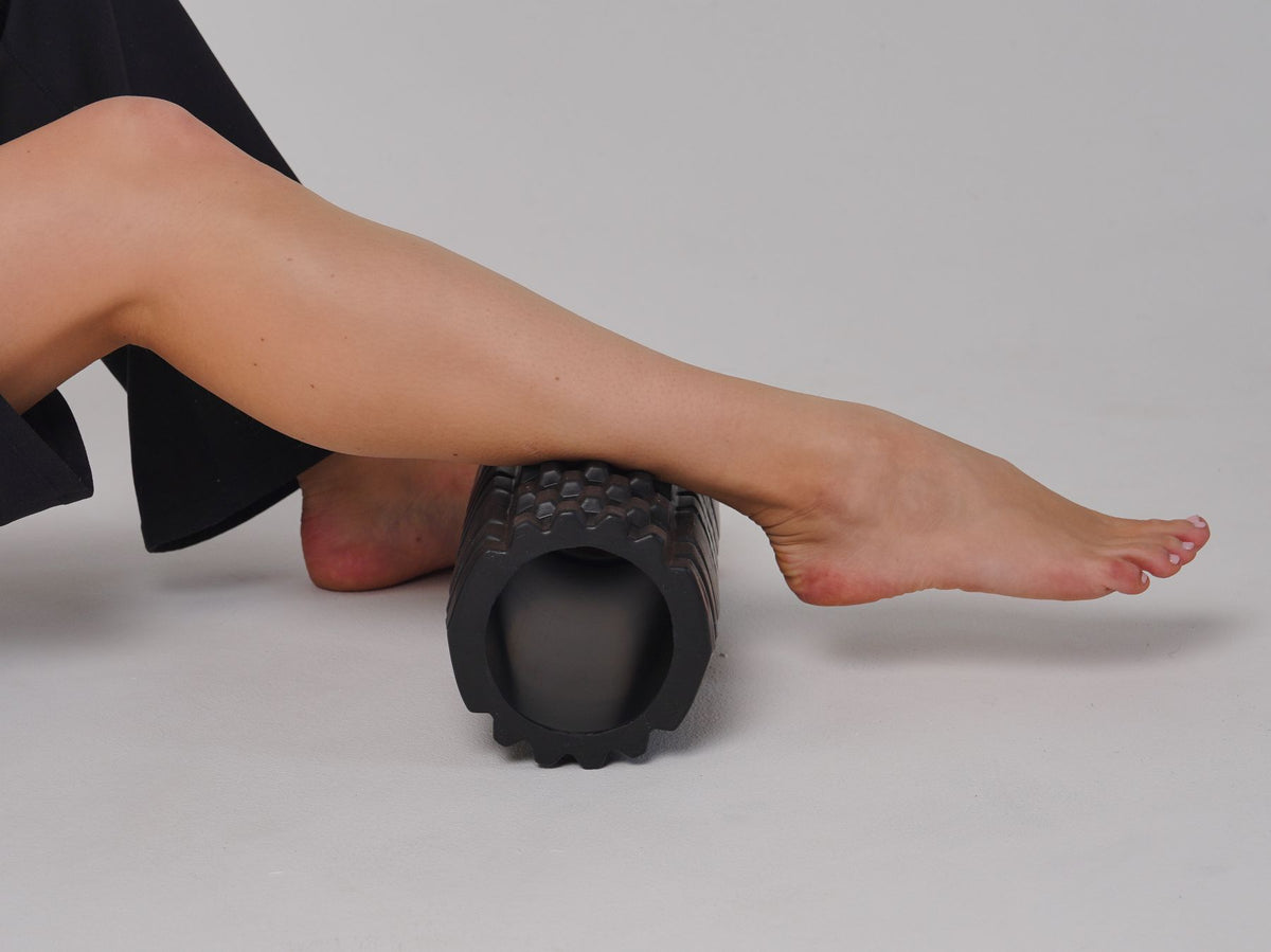 Close-up of a leg on a foam roller during a stretching session