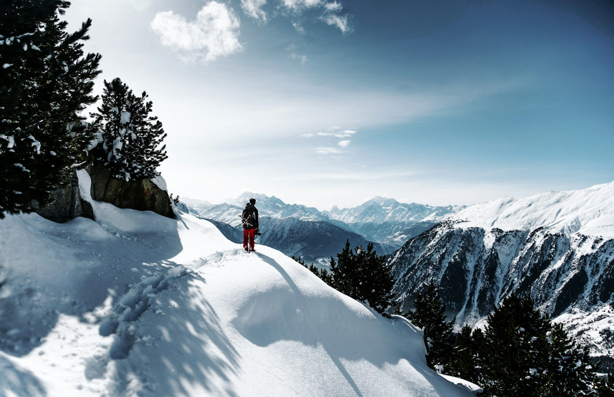 Person walking on a snowy mountain trail in winter